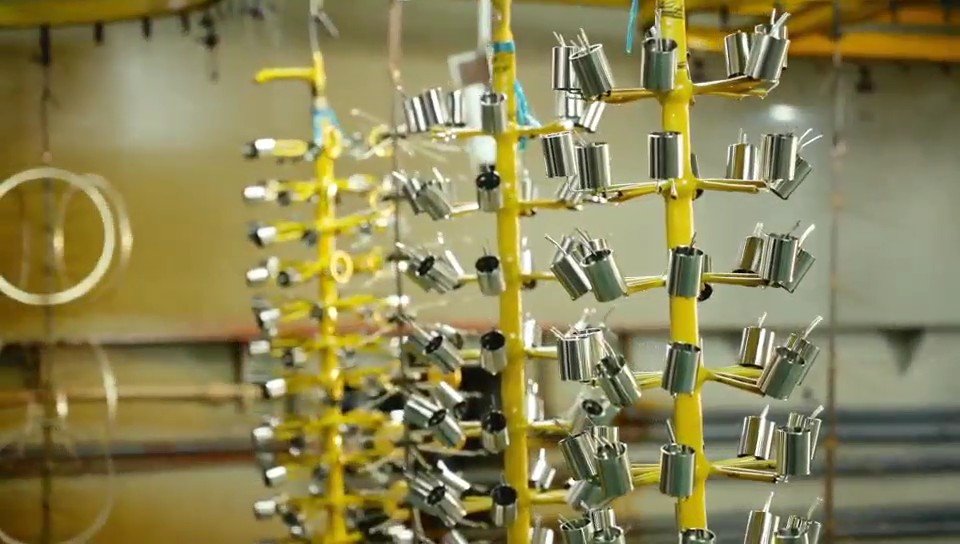 Small metal lighting components arranged for surface finishing