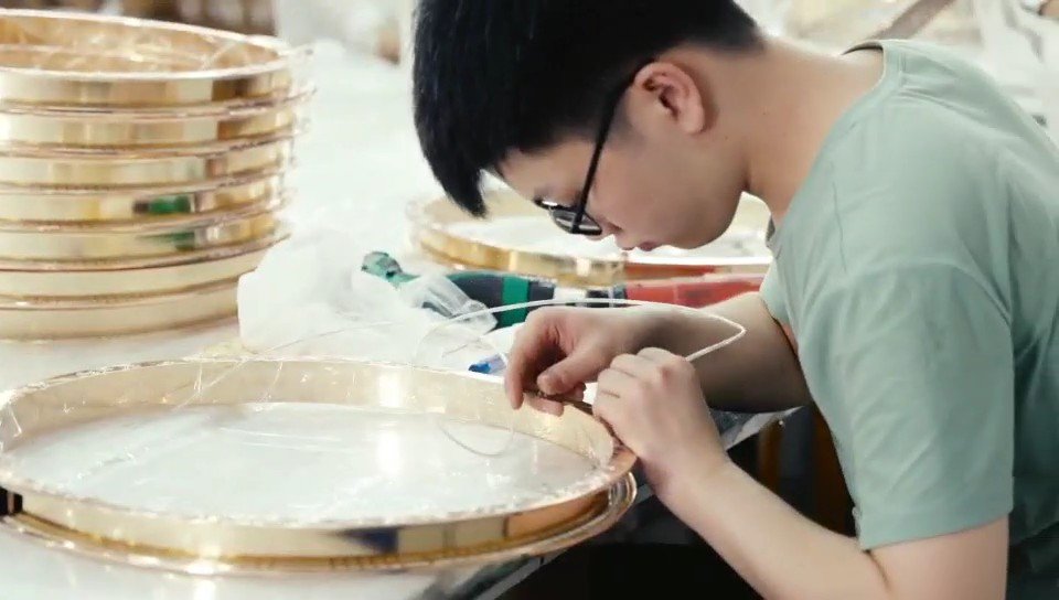 Hand assembly of a circular lighting frame at our partner workshop