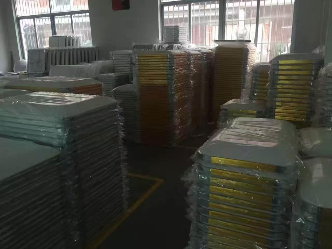 Finished aluminium lighting panels stacked in the workshop