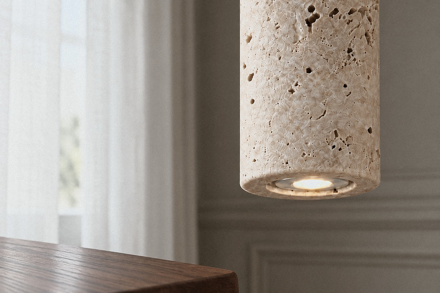 Close view of a travertine pendant with walnut details against sheer linen curtains